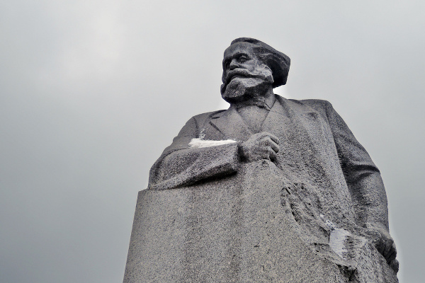 Estátua de Karl Marx, com o braço direito apoiado sobre uma pedra, em um monumento localizado em Moscou, na Rússia.