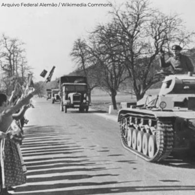 fotagrafia histórica tanque de guerra e pessoas acenando