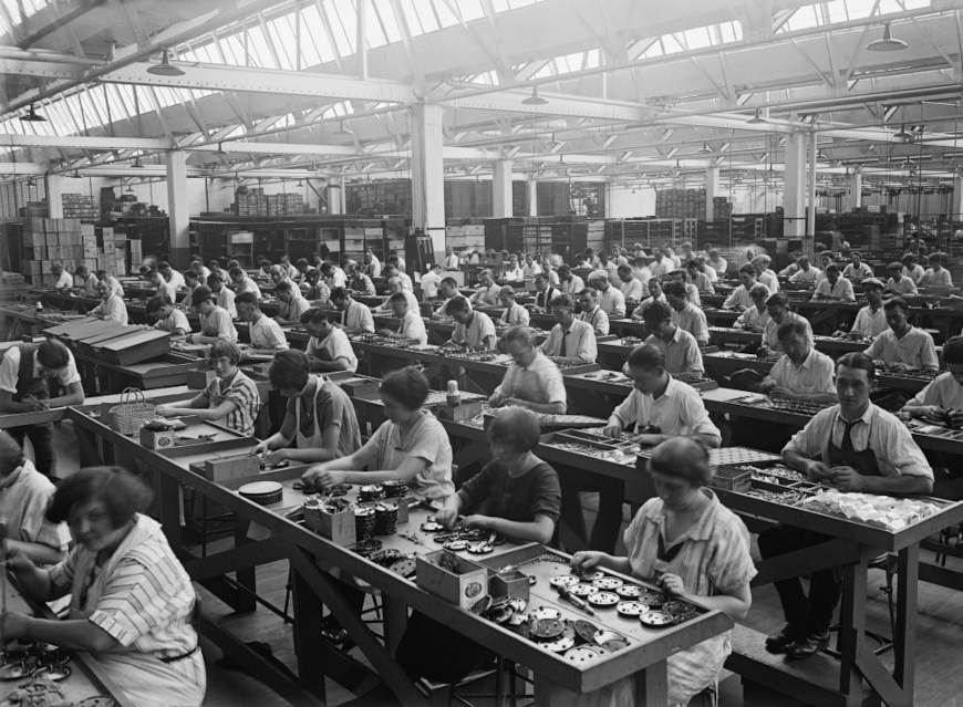 Homens e mulheres trabalhando em uma manufatura de rÃ¡dios.