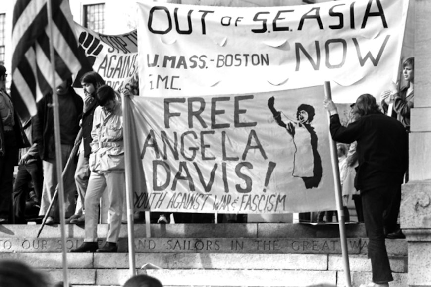 Pessoas segurando cartazes em protesto pela libertaÃ§Ã£o de Angela Davis.