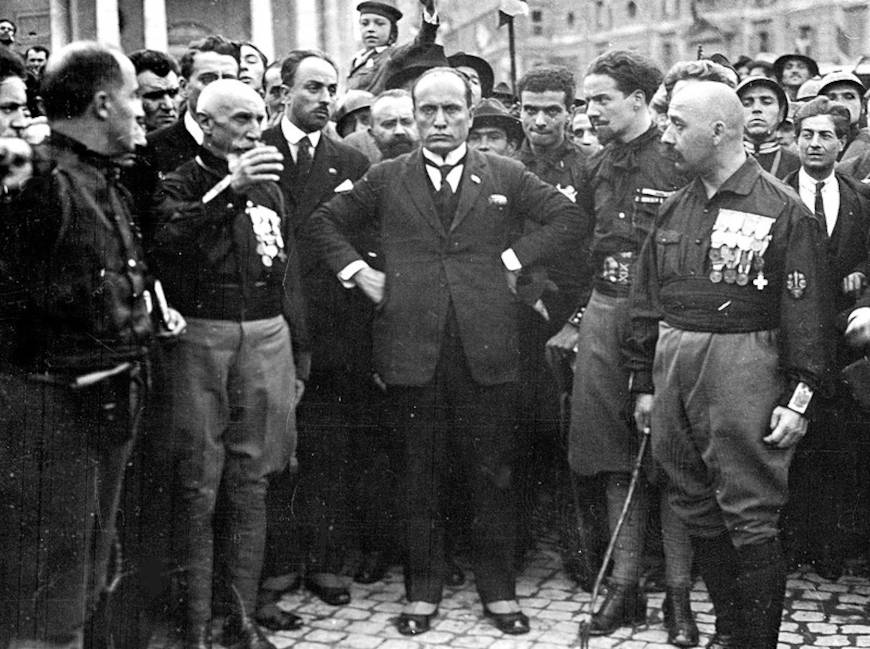 Benito Mussolini, líder do fascismo italiano, entre membros dos Camisas-Negras, espécie de milícia fascista.