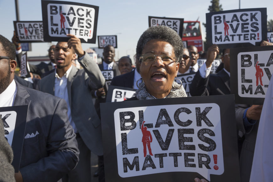 Manifestantes negros segurando cartazes do movimento negro Black lives matter.