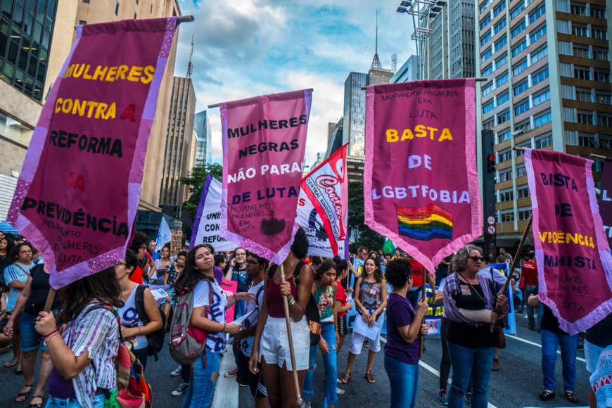 Mulheres erguendo bandeiras em um protesto feminista.