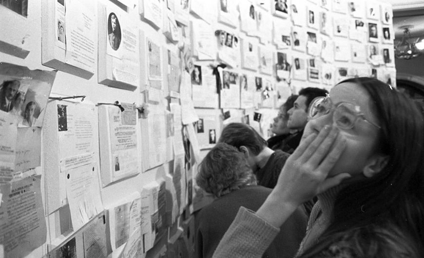 Soviéticos lamentando em frente a fotos de vítimas do stalinismo, no contexto da perestroika e da glasnost.