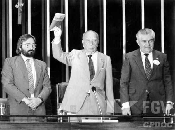Ulisses Guimarães segurando a Constituição, símbolo da Nova República.
